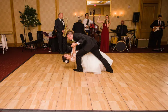 Bride and groom dancing in the middle of the dance floor with the live band behind